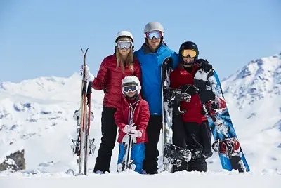 Famiglia con sci e snowboard in una stazione sciistica in Turchia